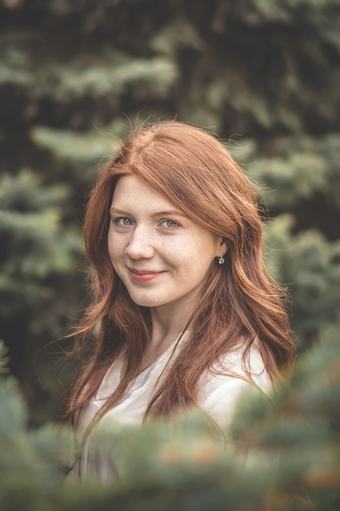 Portret uśmiechniętej Claire Dubois wśród zieleni